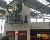 Foto von einer Kölschkneipe am Flughafen Köln/Bonn. Zu sehen ist eine Uhr mit römischen Ziffern, daneben zwei menschliche Figuren. Unter der Uhr steht "Wat mer em Drunk säht, dat hät mer em Nöchter jedach"
